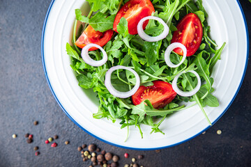arugula and tomato salad vegetable in a plate fresh portion ready to eat meal snack on the table copy space food background rustic. top view keto or paleo diet veggie vegan or vegetarian food