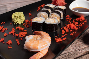 sushi rolls on a black plate with decoration
