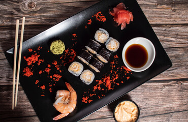 sushi rolls on a black plate with decoration
