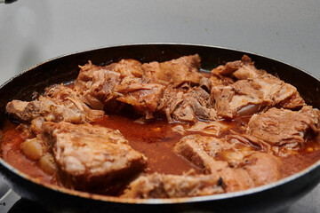 pork meat stew cut into pieces in meat sauce with some spices