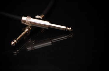 Two silver TRS connectors for the analog audio signal are placed against a black background. Professional jack connectors for sound equipment. Audiophile technologies concept.