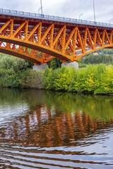 A transport bridge made of bright orange piles and beams across the Moscow Canal. Russia
