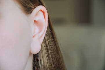 ear of the girl in the frame at home. the concept of hearing and health, eavesdropping and gossip