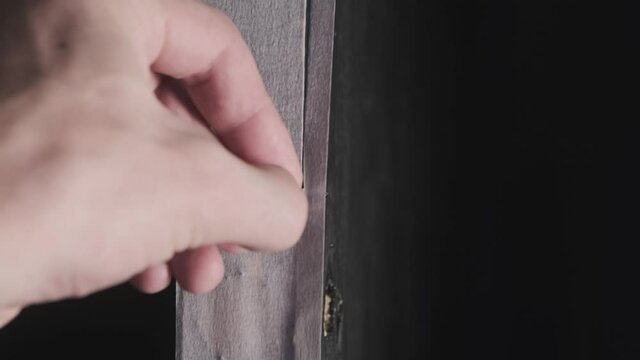 A male hands cutting a masking tape with help of cutter knife 