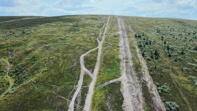 White trail through the green landscape of Dalarna, Sweden -Aerial