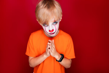 boy with halloween makeup folded his palms in front of him and prays.