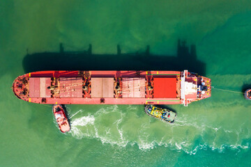 Industrial seaport Novorossiysk , top view. Bulk carrier, Multipurpose or General cargo enters the port using tugs.