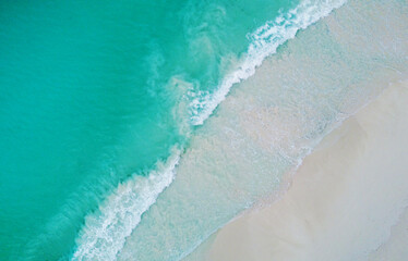Top view of the beautiful ocean shore with waves and foam on the sand. Seychelles. Texture and background tourism design