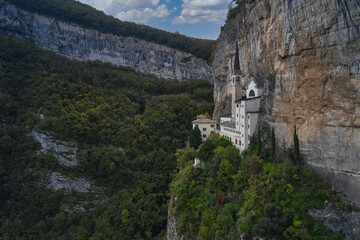Fototapeta na wymiar The unique Sanctuary Madonna della Corona church in the rock. Aerial view of the church on the sheer cliff. Italian church at high altitude in the Alps. The sanctuary is high in the mountains of Italy