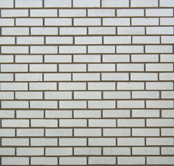 Exterior wall in white brick in classic subway tile pattern with dark grey mortar.  Background or back drop image.
