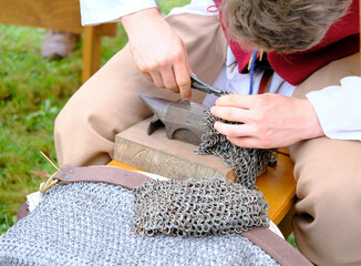 Artisan forgeron travaillant sur un reproduction de cote de mailles