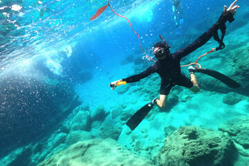 Underwater photo of spear fishing diver in deep emerald exotic paradise bay