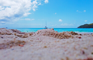 Beautiful view of the beach of a tropical island with a yacht on the horizon. Seychelles