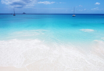 Fototapeta na wymiar Beautiful view of the beach of a tropical island with a yacht on the horizon. Seychelles