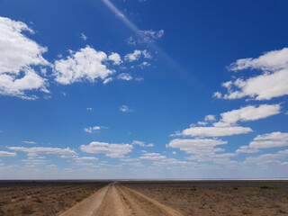 Fototapeta na wymiar landscape a road in the steppe stretching into the distance and a blue sky with clouds. High quality photo