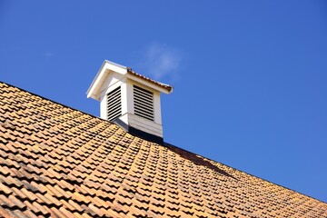 Smoke stack on the tiled roof of a family house