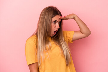 Young Russian woman isolated on pink background excited pointing with forefingers away.