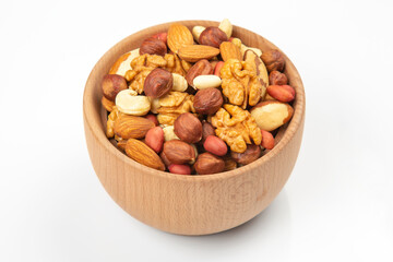 Obraz na płótnie Canvas assortment of nuts in a wooden plate on a white background. vitamin organic food