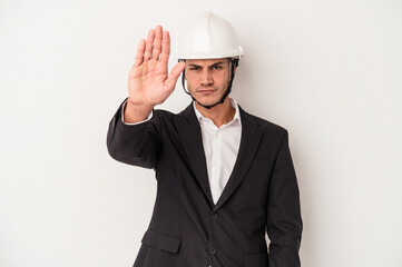 Young architect caucasian man isolated on white background standing with outstretched hand showing stop sign, preventing you.