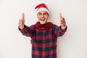 Young caucasian man celebrating Christmas isolated on white background receiving a pleasant surprise, excited and raising hands.
