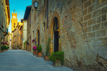 Paved street and entrances decorated with colorful flowers, Pienza, Italy