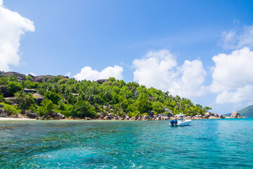 Seychelles, motor boat against the tropical backdrop of the rocky island.