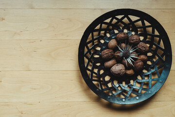 Overhead view of decorative metal dish on a wooden table with copy space on the left