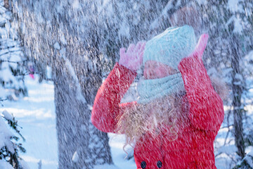 Blurred photo. Girl snowfall on the background of the forest. A child under the snow. Bad weather...
