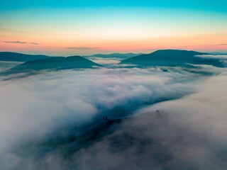 Fototapeta na wymiar Fog in the mountain valley at dawn. Ukrainian Carpathians in the morning in the haze. Aerial drone view.