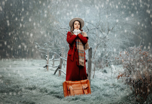 Woman In Red Coat, And Hat With Suitcase At Snow Countryside