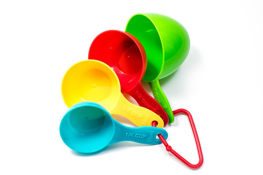 Four pieces of colorful ingredient measuring scoops or spoons of different cup sizes connected together. Isolated on white background with Clipping path