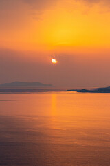 Coastline View of Sun Peaking Through Clouds in Mykonos Greece