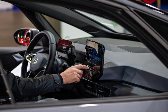 inside view of the Volkswagen (VW) ID4 electric car, driver setting up satnav using touchscreen