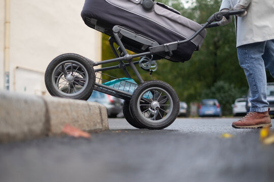 Mother Pushing Baby Pram At A Pedestrian Crossing