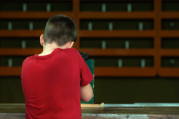A teenage boy shoots a gun at a shooting range at targets