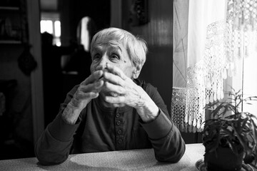 An old woman during a lively conversation. Black and white photo.