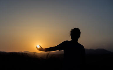 Obraz na płótnie Canvas silhouette of a person sitting on a sunset