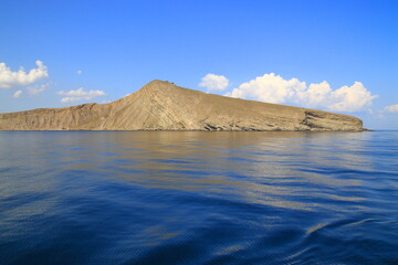The seashore in sunny weather, a view of the cape and a calm sea. Suitable for photo wallpapers, photo frames and lovers of water landscapes.