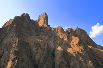 The rocks of the mountain against the blue sky. Suitable for interior, photo wallpapers, photo frames and lovers of mountain landscapes.