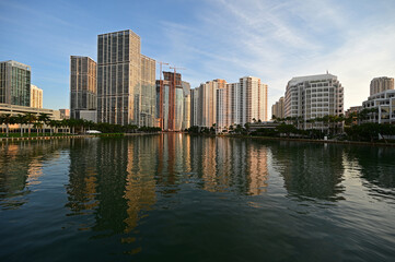 Fototapeta na wymiar City of Miami, Florida skyline reflected in still water of Biscayne Bay at sunrise.