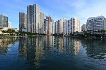 City of Miami, Florida skyline reflected in still water of Biscayne Bay at sunrise.