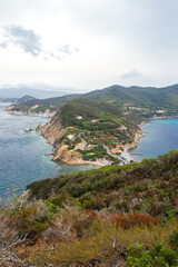 Fototapeta na wymiar Aerial view of the northern little peninsula in Elba island seen from the top of Monte Enfola, typical mediterranean vegetation and rocky landscape