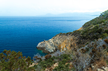 Fototapeta na wymiar Wild sea landscape with white rocks and blue water in Monte Enfola, Elba island, Italy