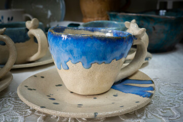 Multi-colored handmade ceramic bowls and cups covered with glaze in the pottery workshop
