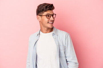 Young caucasian man isolated on pink background relaxed and happy laughing, neck stretched showing teeth.