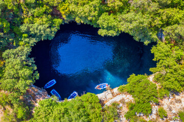 Famous tourist attraction. Aerial drone view of iconic cave with Melissani Lake near Sami village,...
