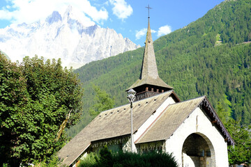 old little Chapelle, Les Praz Church in Chamonix-Mont-Blanc, building among green trees and high...