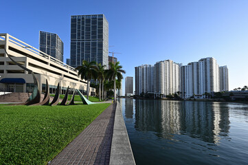 City of Miami, Florida skyline reflected in still water of Biscayne Bay at sunrise.