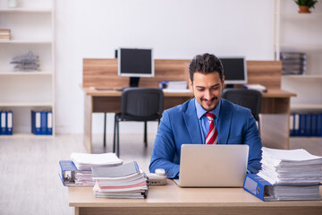 Young male employee unhappy with excessive work at workplace