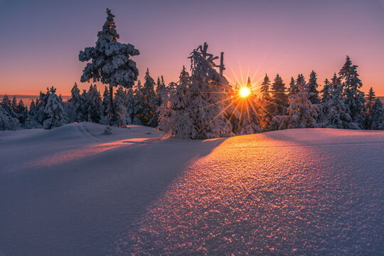 Beautiful winter sunset with sunstar at the mountain